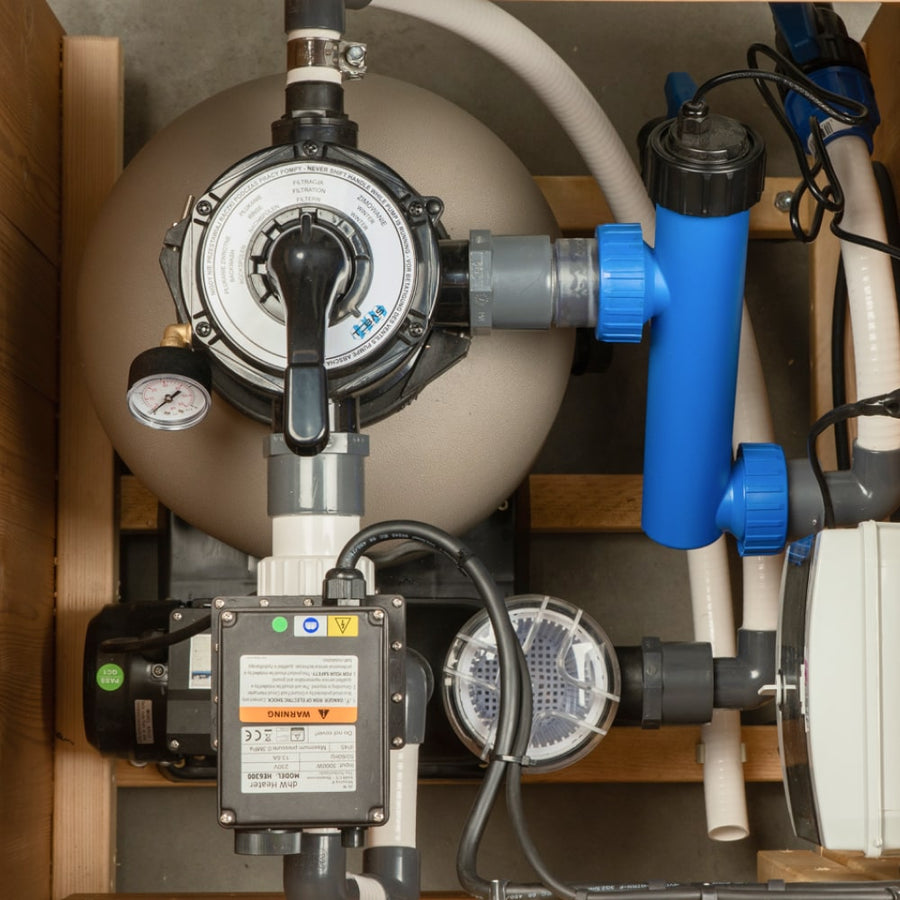 Top-down view of premium sand filter system with multi-port valve and pressure gauge for wood-fired hot tub maintenance