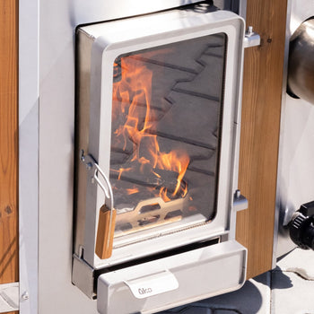Close-up of integrated stainless steel Verta stove with glass door and visible fire inside wood fired hot tub heater
