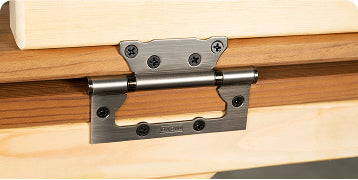 Close-up of stainless steel hinge attached to light and dark wooden surfaces with black screws
