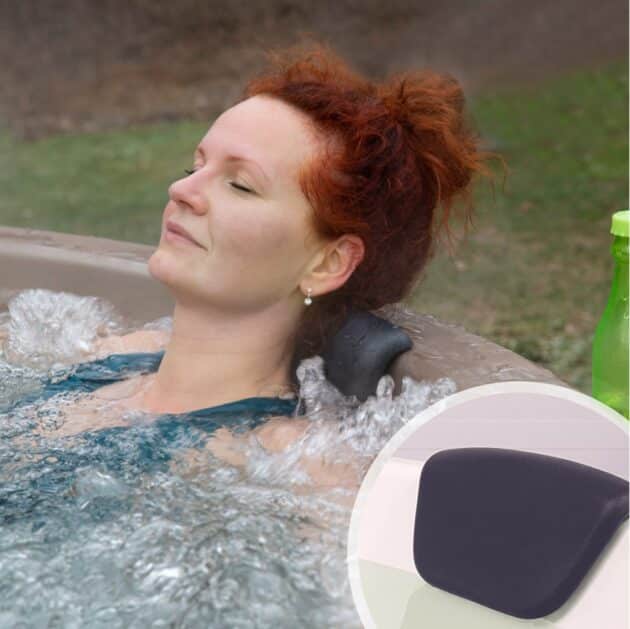 Une femme se détend dans un bain nordique chauffé au bois, s'appuyant sur un appui-tête rembourré